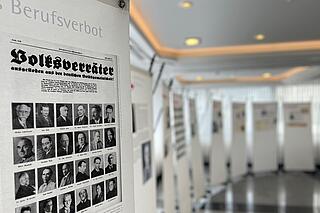 Foto eines Panels mit einer Bildertafel mit Anwälten mit Berufsverbot. Darüber eine Überschrift "Volksverräter"